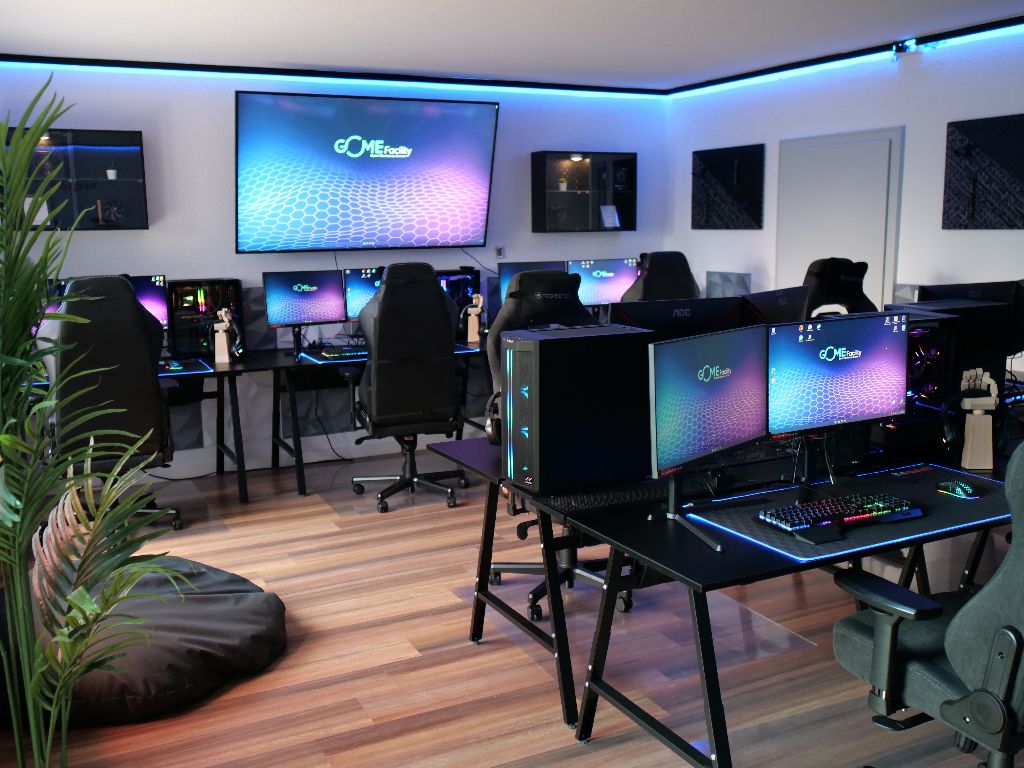 Gaming-Arena der GOME Facility mit beleuchteten Setups