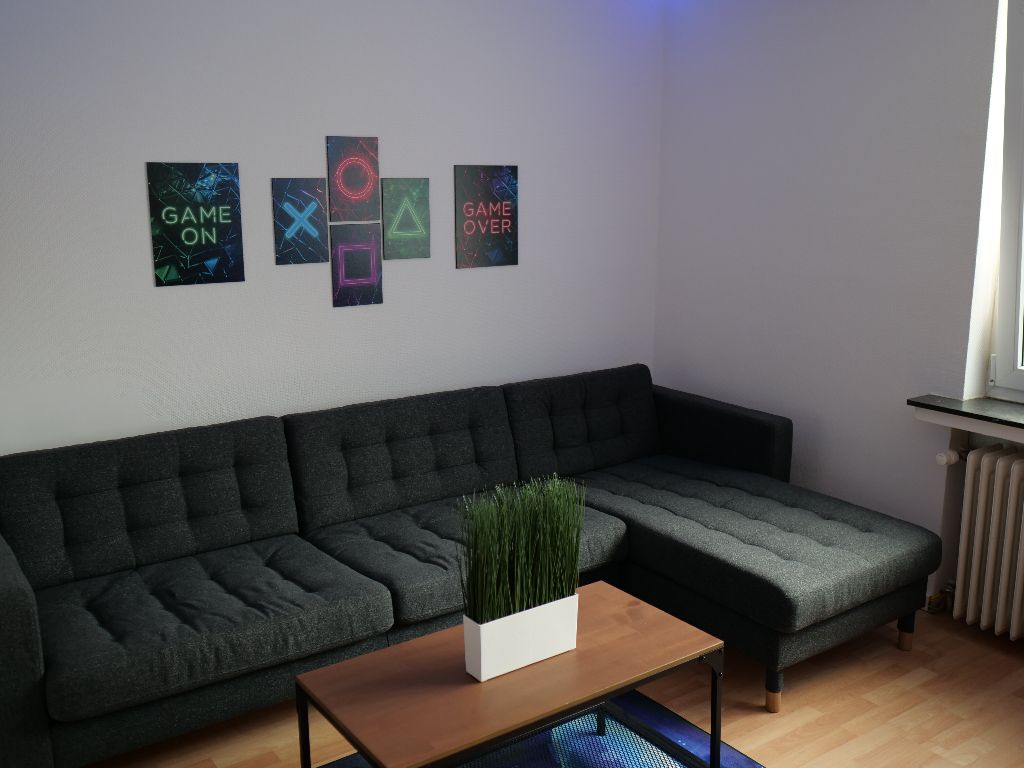 Lounge der GOME Facility mit Sofa und Postern
